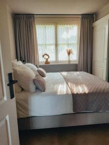 Un dormitorio con una cama grande con ventana. en NIEUW vanaf juli 2025 Vakantiewoning Borkeldrust, en Rijssen
