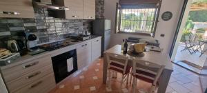 een keuken met een aanrecht en een tafel met stoelen bij Villa Virginia Porto Pino in Porto Pino
