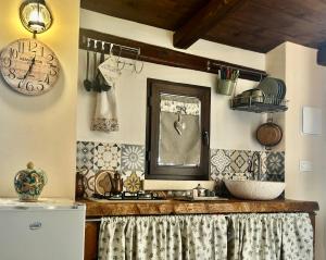 a kitchen with a sink and a mirror on the wall at "The Cottage"with sea view, parking & wifi in Avola