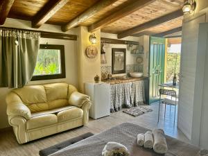 a living room with a couch and a kitchen at "The Cottage"with sea view, parking & wifi in Avola