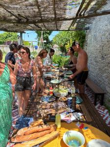 a group of people standing around a table with food at Têtes à l'air in Montils