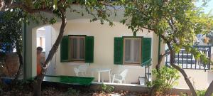 una casa con persiane verdi e tavolo e sedie di Chris's house in Spetses a Spetses