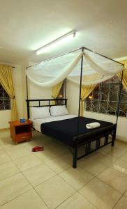 a bedroom with a black bed with a canopy at Misenani House njiro in Arusha