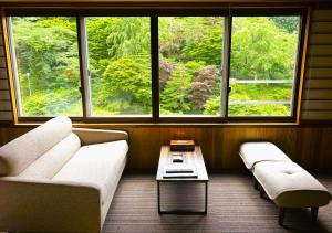 a living room with a couch and a table and windows at Yuze Hotel in Kazuno