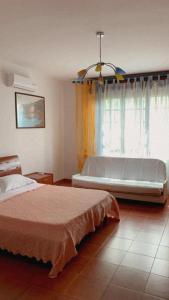 a bedroom with a large bed and a window at Il Bouganville in Oristano