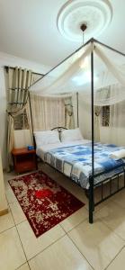 a bedroom with a canopy bed and a rug at Misenani House njiro in Arusha