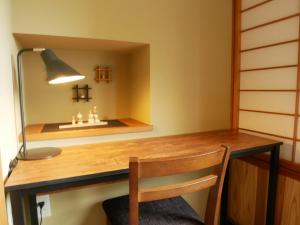 a desk in a room with a lamp and a chair at Yuze Hotel in Kazuno
