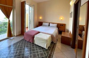 a bedroom with a bed and a large window at GR B&B in Alì Terme