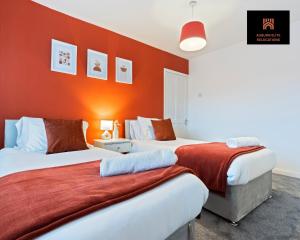 two beds in a room with orange walls at Stylish 3 Bedroom Contractor Stay House in Birmingham B23 near M6 & Fort Dunlop with Free Parking and WiFi in Birmingham