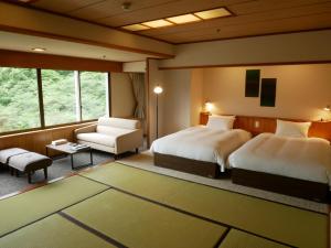 a bedroom with two beds and a couch and a chair at Yuze Hotel in Kazuno +75 photos