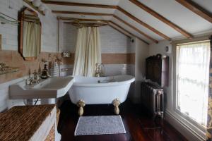 ein Badezimmer mit großer Badewanne und Waschbecken in der Unterkunft Black Tile Cottage in Lewes + 17 Fotos