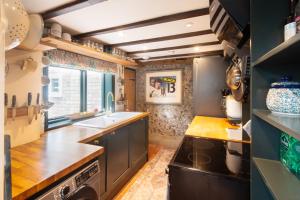 eine Küche mit Spüle und Herd in der Unterkunft Black Tile Cottage in Lewes