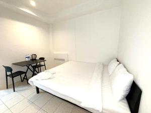 a white bedroom with a bed and a table at Patong Canal Villa R105 in Patong Beach