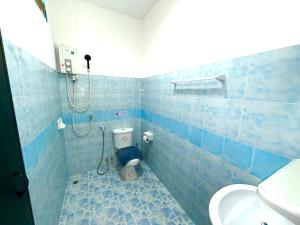 a blue tiled bathroom with a toilet and a shower at Patong Canal Villa R105 in Patong Beach