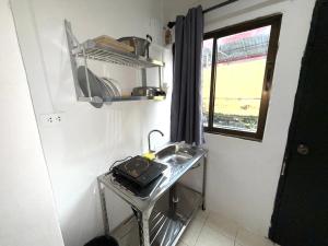 a small kitchen with a sink and a window at Patong Canal Villa R105 in Patong Beach +5 photos
