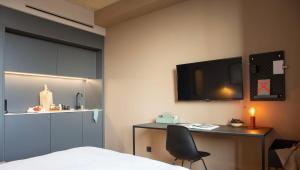una habitación con una cama, un escritorio y un televisor en ipartment Cologne Oper, en Colonia 5 fotos más