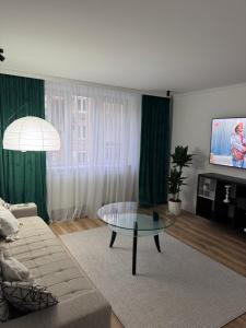 ein Wohnzimmer mit einer Couch und einem Glastisch in der Unterkunft Ianis Home in Hunedoara