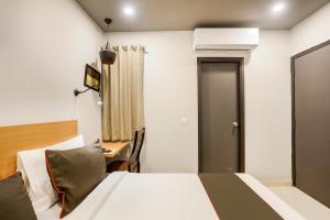 a bedroom with a bed and a desk and a room at Collection O Le Noida Hotel Near Sector 76 Metro Station in Noida +28 photos