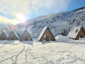 a group of wooden cabins in the snow at JAGI Bungalovi Mrkonjic Grad in Mrkonjić Grad