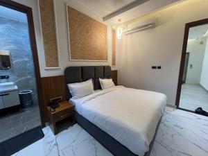 Un dormitorio con una cama grande y un baño. en Hotel Royal Vista, en Amritsar