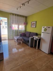 a living room with a couch and a refrigerator at Apartamento Riells in L'Escala