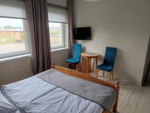 a bedroom with two chairs and a bed and a tv at 117 in Łeba