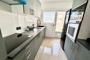 a kitchen with white cabinets and a black counter top at Antibes hyper center - 4 people - close to shops and beaches in Antibes