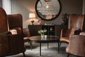 a living room with chairs and a table and a mirror at Home Hotel Etage in Västerås