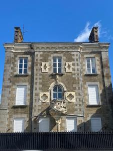 an old brick building with stars on it at 4 pièces 90 m2 5 lits Wifi dans Maison de Maître in La Ferté-Macé