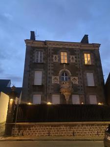 a large brick building with a clock on it at 4 pièces 90 m2 5 lits Wifi dans Maison de Maître in La Ferté-Macé