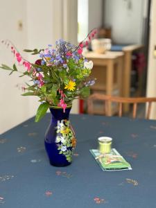 a blue vase with flowers in it on a table at Vergissmeinnicht - Das Haus in Kurort Oberwiesenthal +22 photos