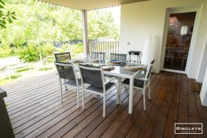 a white dining room table and chairs on a deck at Superbe T3 climatisé avec WIFI à 400m de la plage in Vias