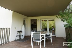 a dining room with a table and chairs on a deck at Superbe T3 climatisé avec WIFI à 400m de la plage in Vias