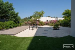 a garden with a chair sitting on the grass at Superbe T3 climatisé avec WIFI à 400m de la plage in Vias