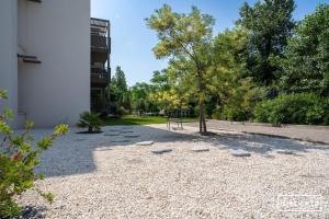 a park with rocks and a tree and a building at Superbe T3 climatisé avec WIFI à 400m de la plage in Vias