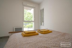 a bedroom with a bed with two yellow towels on it at Superbe T3 climatisé avec WIFI à 400m de la plage in Vias