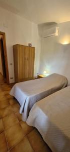a room with two beds and a cabinet in it at Villa Rosmarino in Siniscola +43 photos
