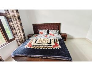 a bedroom with a bed with a blue blanket at casbio hotels in Rudraprayāg