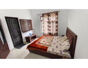 a bedroom with a bed and a window and a door at casbio hotels in Rudraprayāg +9 photos