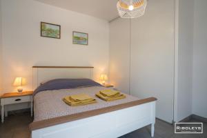 a bedroom with a bed with two towels on it at Superbe T3 climatisé avec WIFI à 400m de la plage in Vias