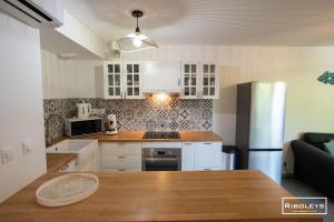 a kitchen with a wooden table and a refrigerator at Superbe T3 climatisé avec WIFI à 400m de la plage in Vias