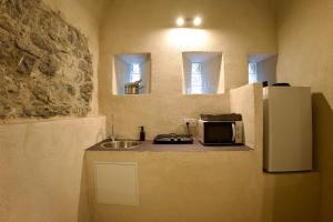 a small kitchen with a sink and a refrigerator at Love Room du Château Fort - Jacuzzi & Insolite ! in Mercury
