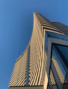 Un edificio alto con un cielo azul al fondo. en Skyline Residence Sarajevo Tower, en Sarajevo