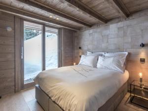 Un dormitorio con una cama grande y una ventana en Chalet 5* calme, cocon raffiné, 12 pers, vue montagne, WIFI, garage - FR-1-304-211, en La Clusaz