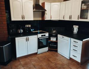 a kitchen with white cabinets and white appliances at Loo puhkemaja Saaremaal in Kudjape