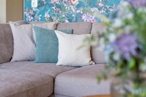 a couch with pillows and a vase of flowers at Haus Dieksee Holm Dieksee-Idyll in Gremsmühlen