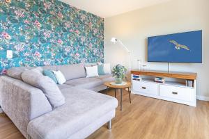 a living room with a couch and a flat screen tv at Haus Dieksee Holm Dieksee-Idyll in Gremsmühlen