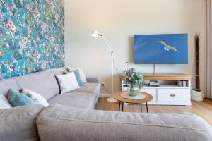 a living room with a couch and a tv at Haus Dieksee Holm Dieksee-Idyll in Gremsmühlen