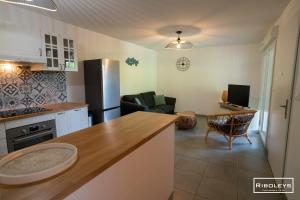 a kitchen and living room with a refrigerator and a table at Superbe T3 climatisé avec WIFI à 400m de la plage in Vias +37 photos