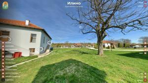 Ein Baum auf einem Feld neben einem Gebäude in der Unterkunft Apartmani "Eliot" in Ilino
